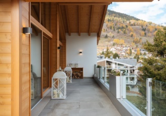 Una casa in legno con grande portico con travi a vista. 