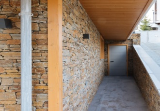 Una villa valorizzata dai materiali del territorio: larice, pietra, intonaco. 