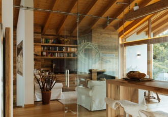 Una prestigiosa villa in bioedilizia con grandi vetrate e travi in legno a vista. 