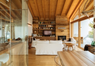 Una prestigiosa villa in bioedilizia con grandi vetrate e travi in legno a vista. 