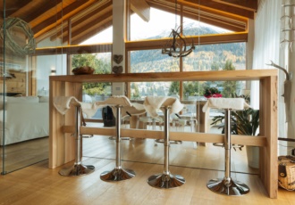 Una prestigiosa villa in bioedilizia con grandi vetrate e travi in legno a vista. 