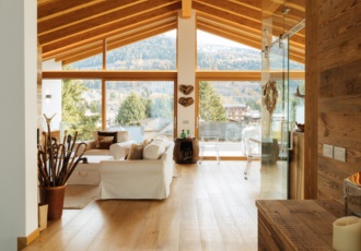 Una prestigiosa villa in bioedilizia con grandi vetrate e travi in legno a vista. 