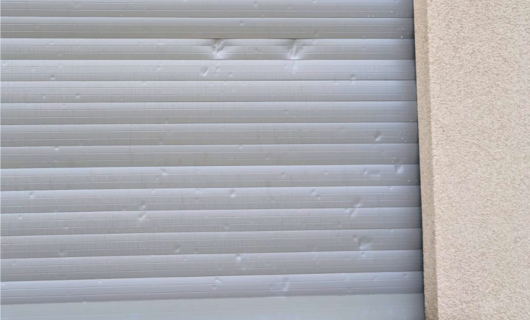Pordenone:il cappotto è integro mentre tapparelle sono tempestate dai colpi della grandine. 