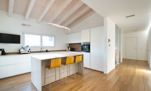 In questa casa in legno la palette di colori chiari risalta l’eleganza della grande cucina 