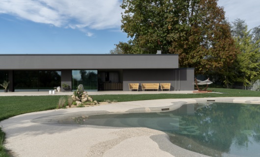 La piscina dalle forme naturali è il coronamento di questa villa in bioedlizia. 